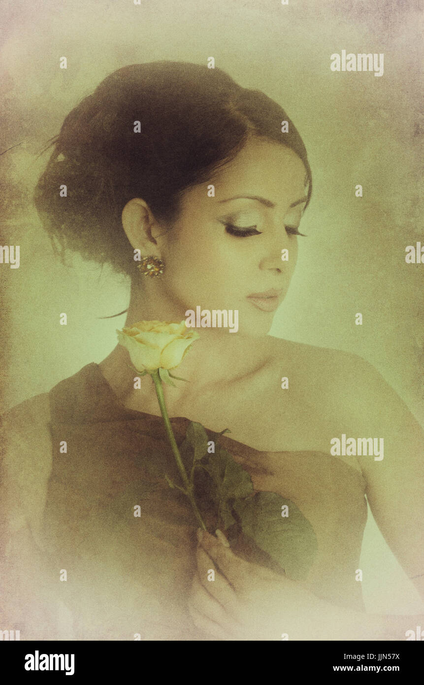 Beautiful young woman holding a yellow rose Stock Photo - Alamy