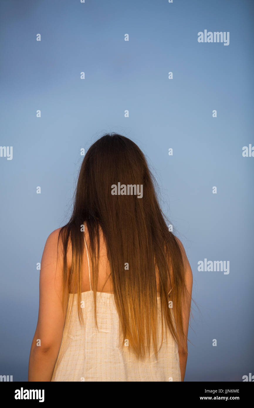 Rear view of a young woman with dark hair standing outdoors Stock Photo ...