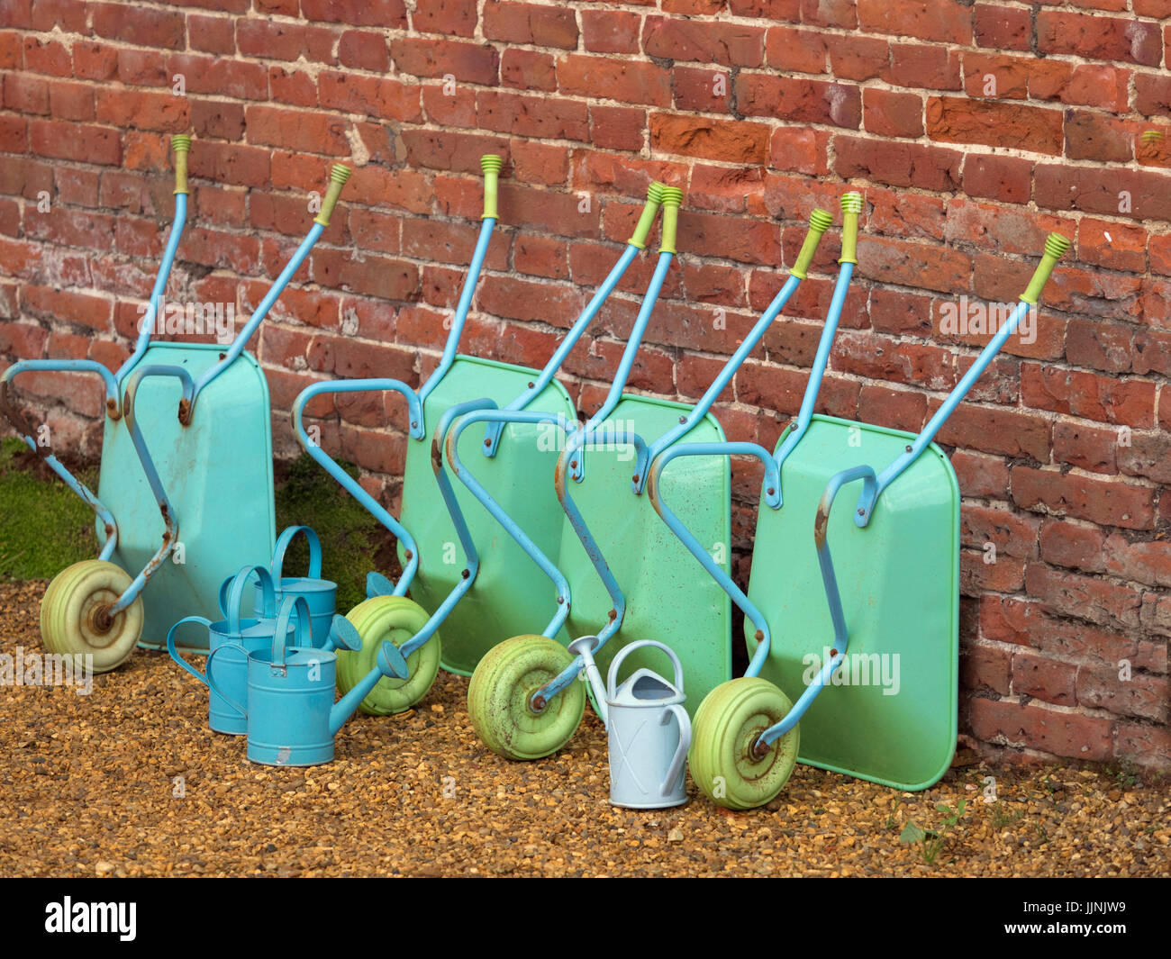 Childrens wheel barrows and watering cans in school gardening project Stock Photo