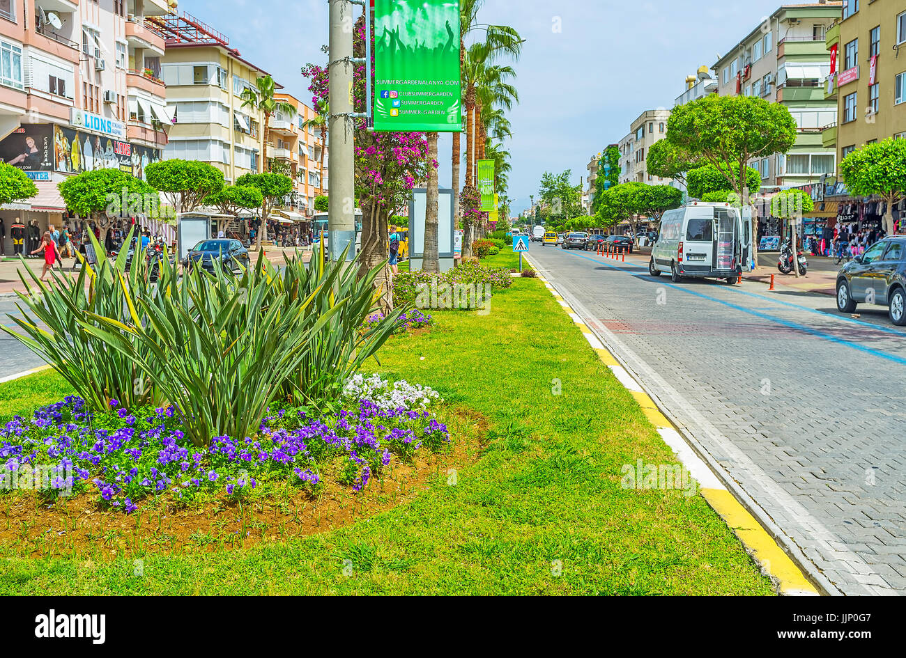 ALANYA, TURKEY - MAY 9, 2017: The Ataturk Boulevard is decorated with scenic flower beds, numerous trees and blooming bushes, on May 9 in Alanya. Stock Photo
