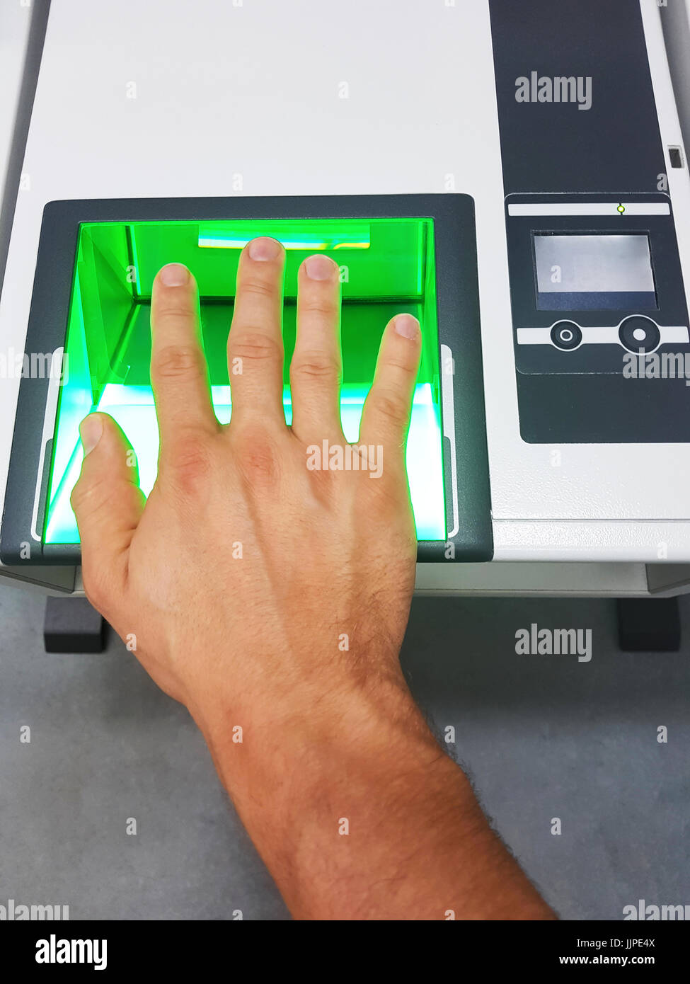 Side view from a man using a fingerprint scanner for identification. Biometrics or cybersecurity concepts. Stock Photo