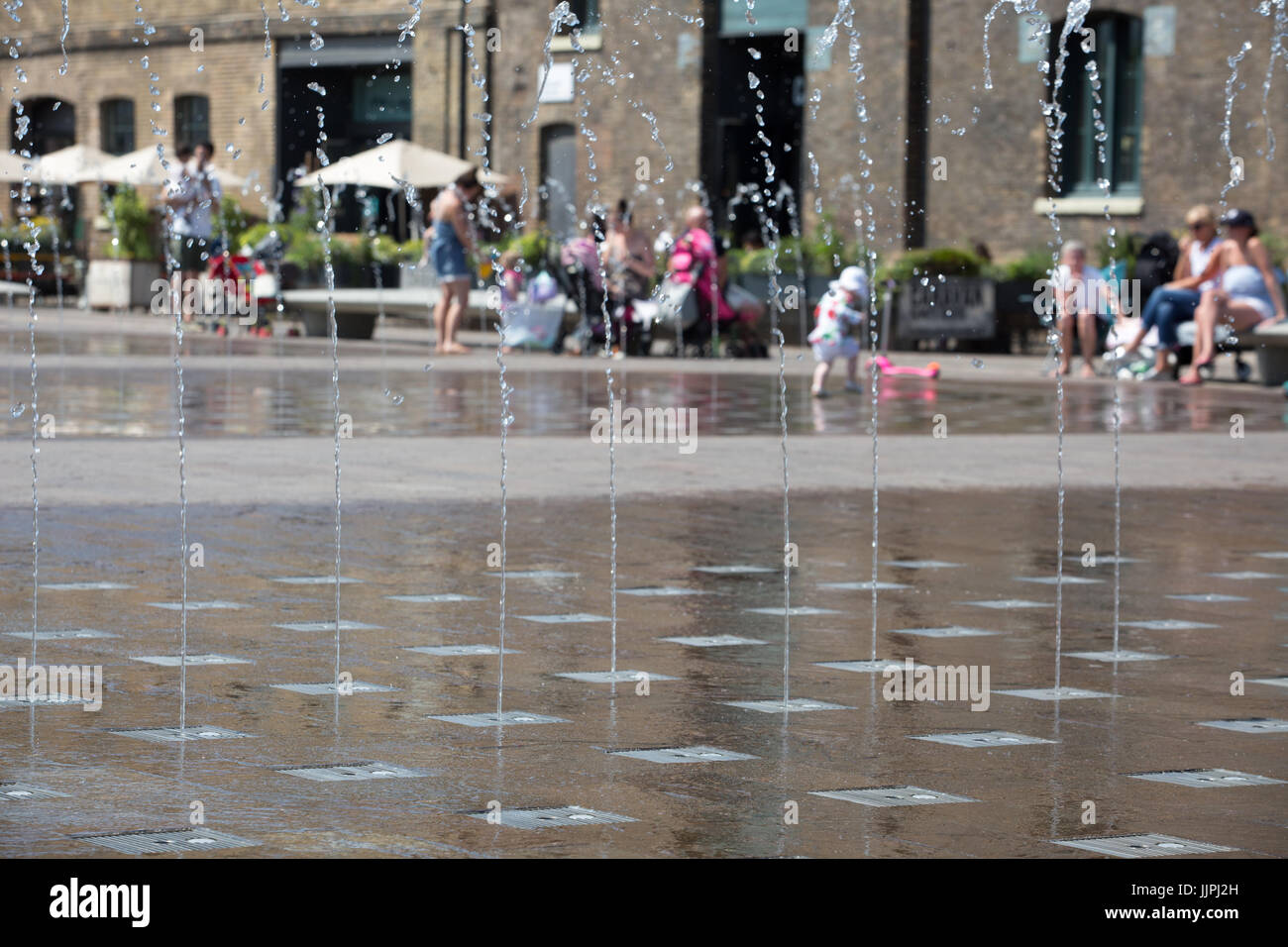 Fountains in Granary Square, London attract youngsters to cool down in