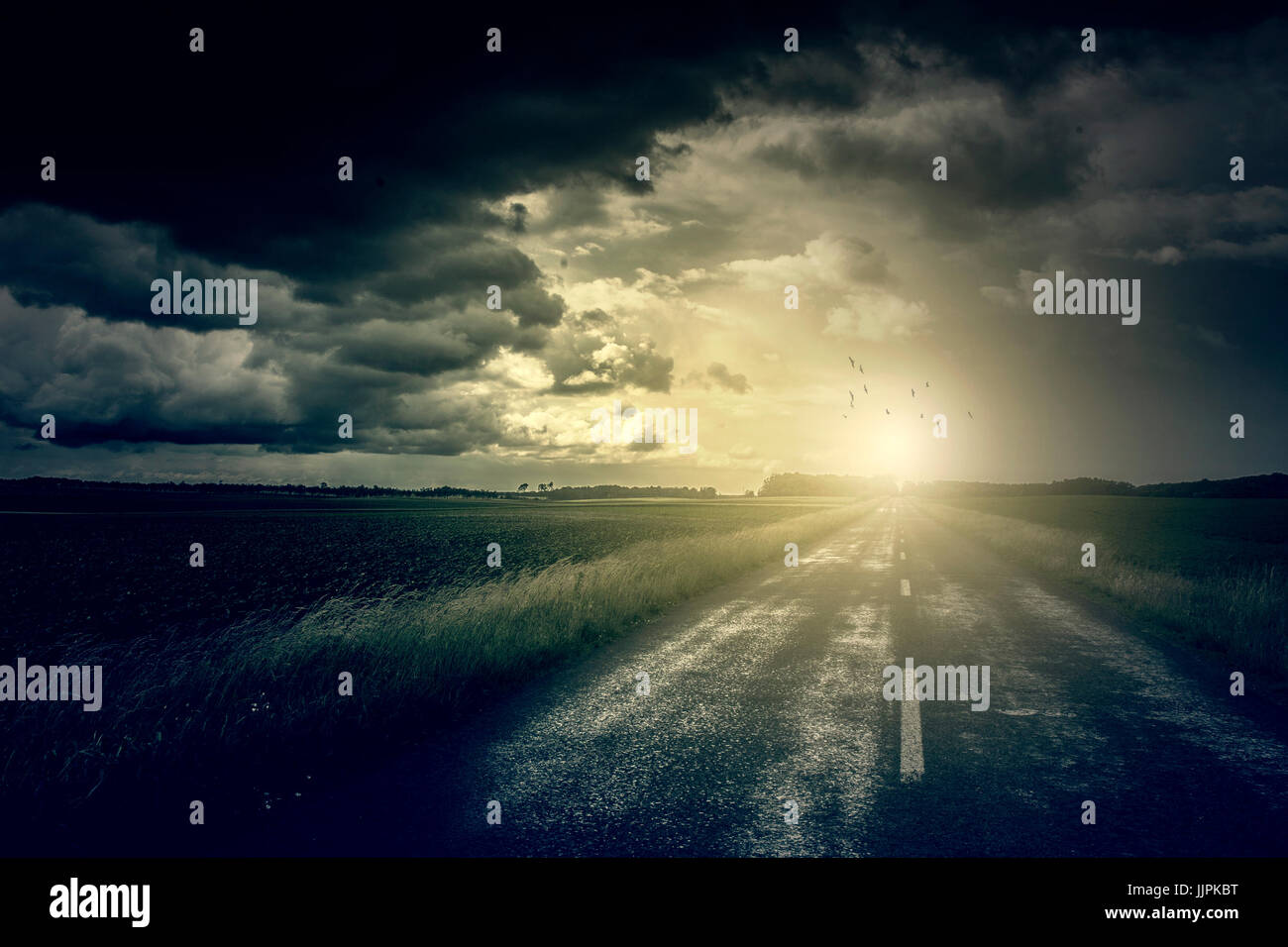 Stormy clouds over road Stock Photo - Alamy