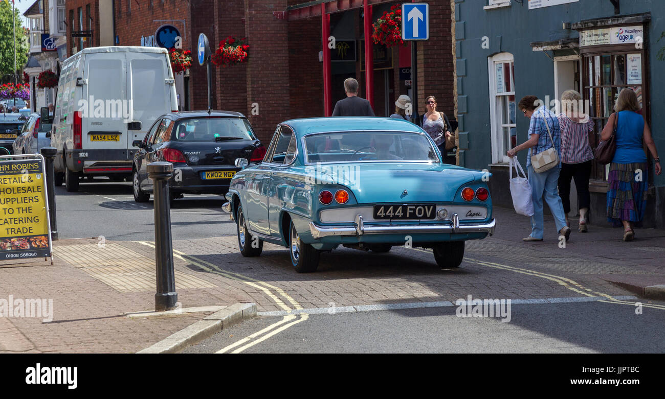 Blue Ford Classic driving up the high street in Stony Stratford, North Buckinghamshire, uk Stock Photo