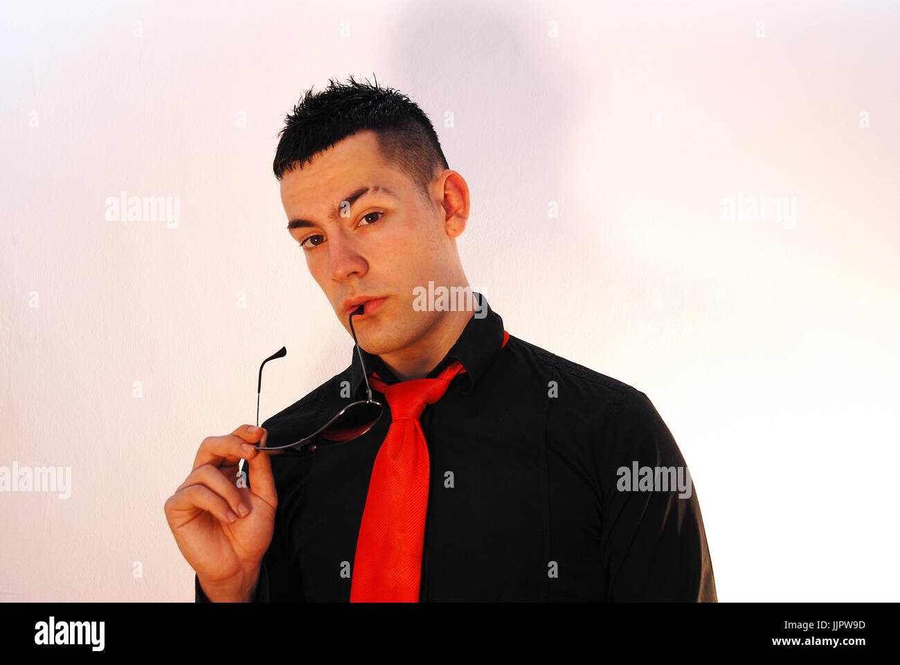 Young executive biting his sunglasses and thinking. Stock Photo