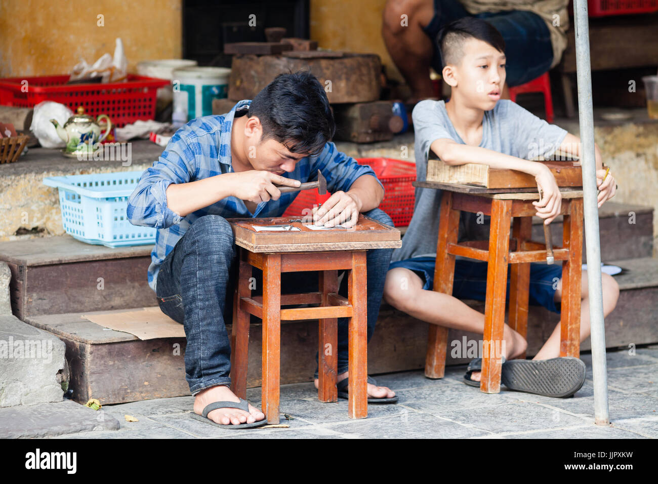 Hoi An, Vietnam - March 14, 2017: Vietnamese craftsmen making ornamental souvenirs Stock Photo