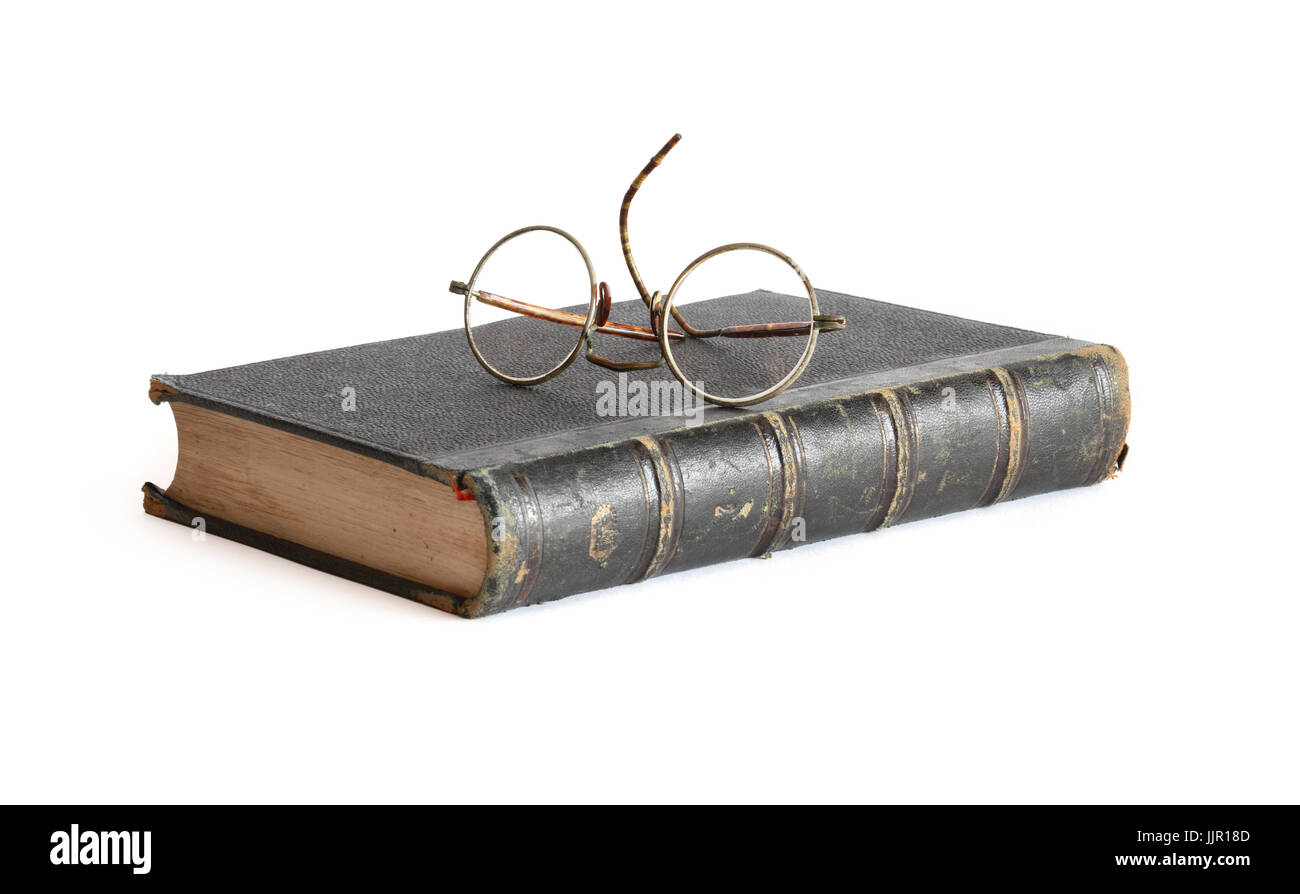 Vintage spectacles lying on old book on white background Stock Photo