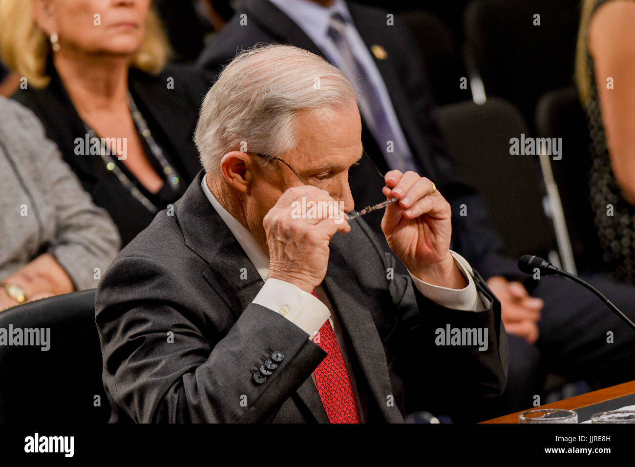 US. Attorney General Jeff Sessions removes his reading glasses after reading his prepared opening statements at the start of his testimony in front of the Senate Intelligence  Committee. Washington DC, June 13, 2017. Stock Photo