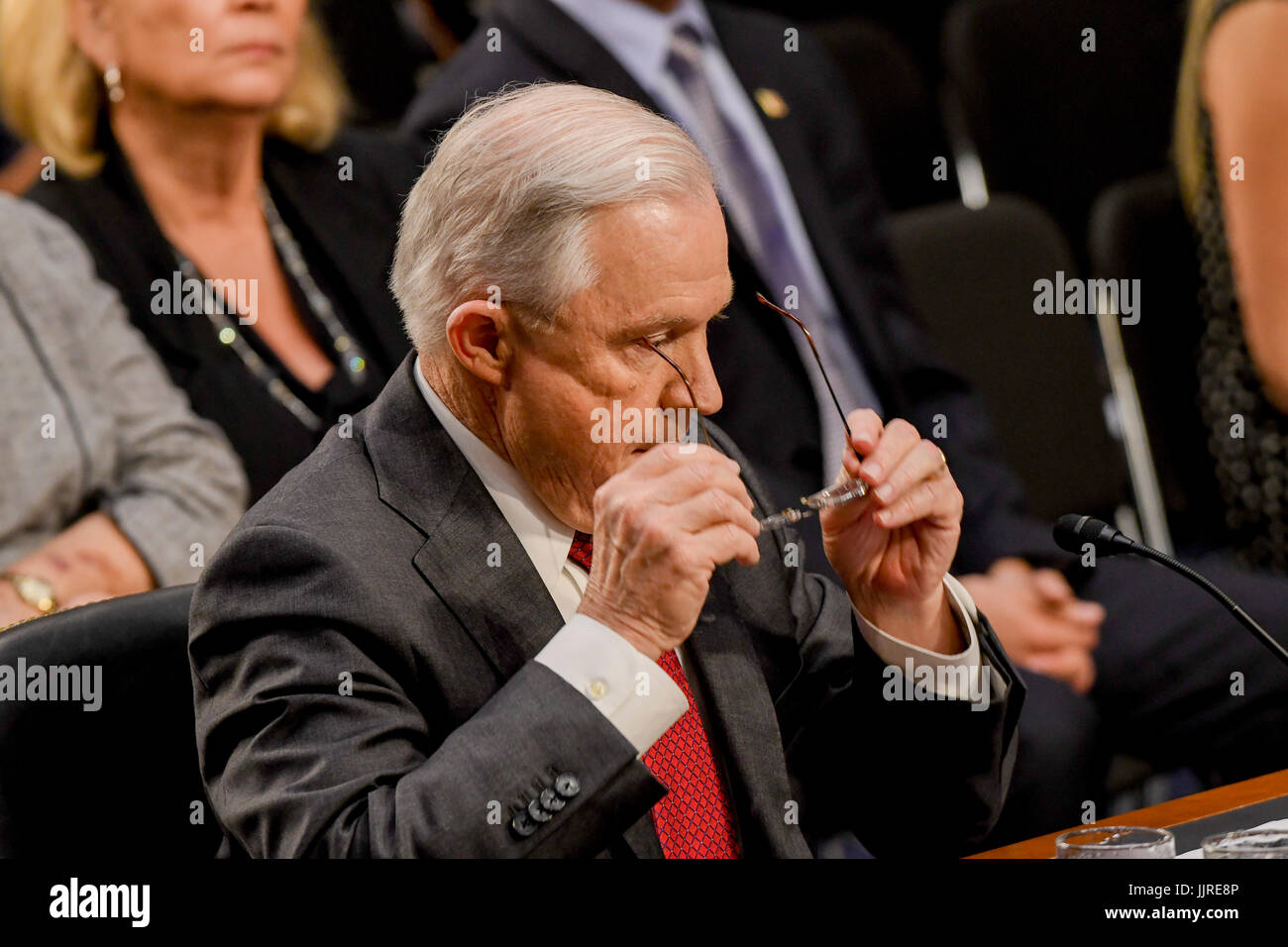 US. Attorney General Jeff Sessions removes his reading glasses after reading his prepared opening statements at the start of his testimony in front of the Senate Intelligence  Committee. Washington DC, June 13, 2017. Stock Photo