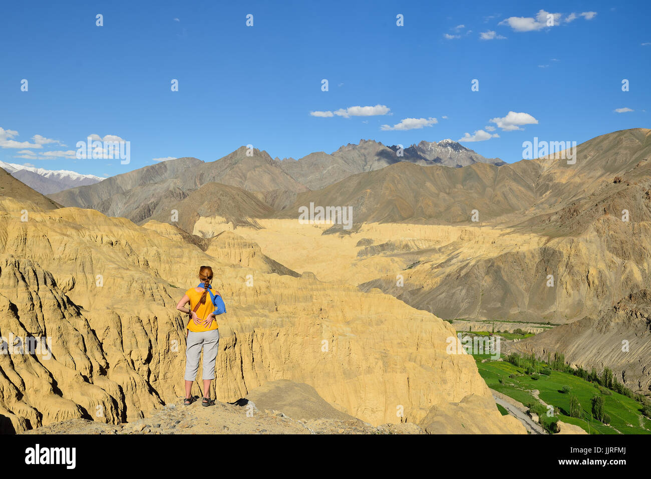 Tourist during expedition in the mountains Ladakh is admiring the beautiful Karakorum panorama in the vicinity of the Lamayuru town. Local are naming  Stock Photo