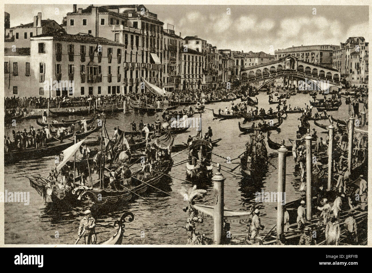 Vintage 1900's B&W image of Regata Storica a main event in the annual 'Voga alla Veneta' rowing calendar. This unique sport has been practised in the Venetian lagoon for thousands of years. A spectacular historical water pageant precedes the race. Scores of typically 16th century-style boats with gondoliers in period costume carry the Doge, the Doge's wife and all the highest ranking Venetian officials up the Grand Canal in a historic parade. Rialto Bridge Venice Stock Photo