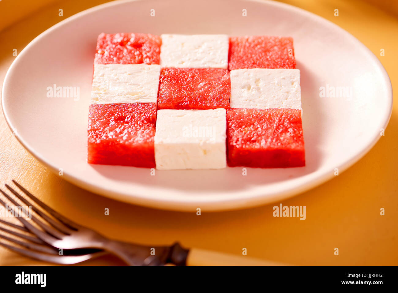 Cubes of watermelon and feta cheese on a plate forming a square pattern. Stock Photo