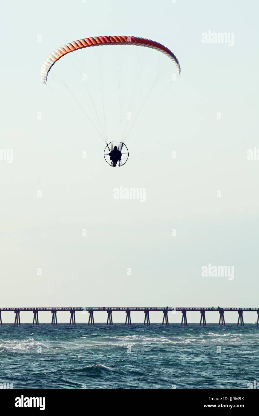 Powered paraglider flying against a clear blue sky Stock Photo Alamy