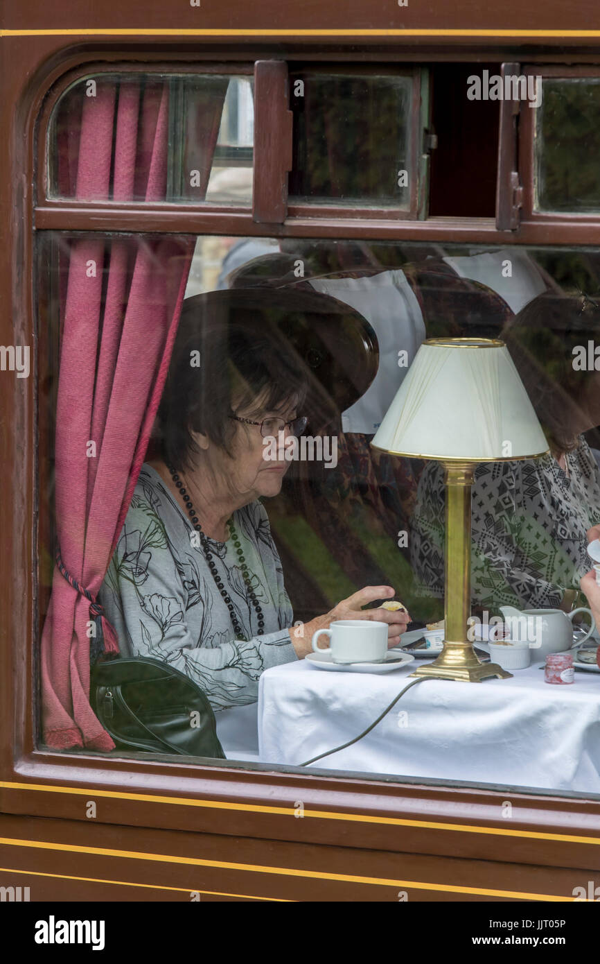 Woman enjoying afternoon tea aboard iconic steam locomotive, LNER Class A3 60103 Flying Scotsman - Keighley and Worth Valley Railway, England, UK. Stock Photo