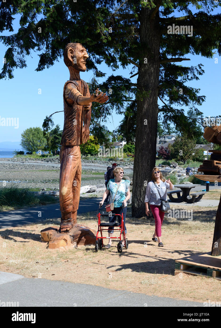 People looking at wood carvings in Campbell River,  British Columbia,Vancouver Island, Canada. Stock Photo