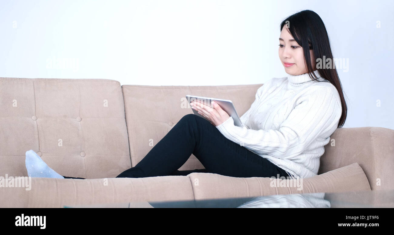 young happy asian woman sitting on sofa using Digital Tablet Stock ...