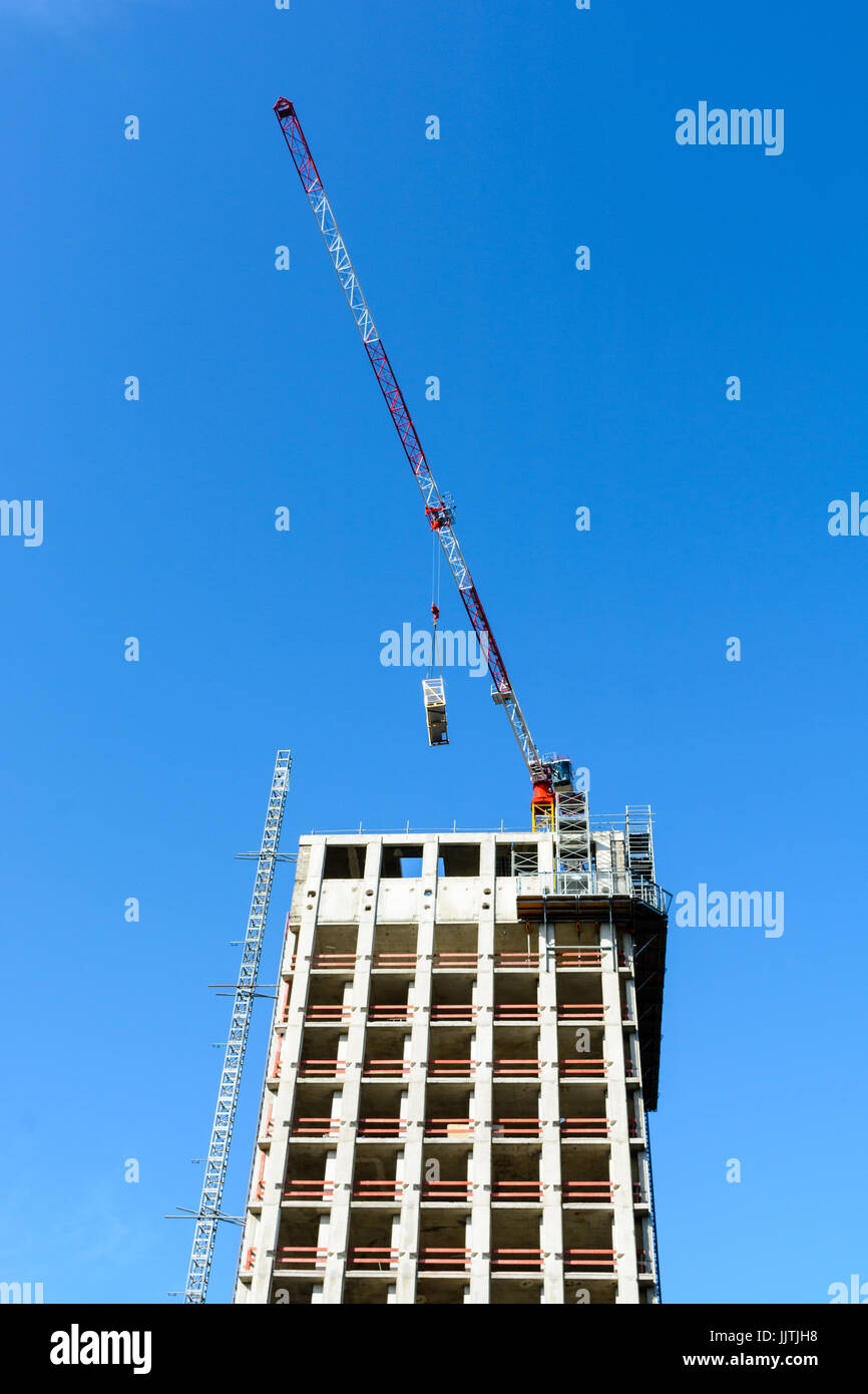 Low angle view of a concrete building under construction with a red and ...