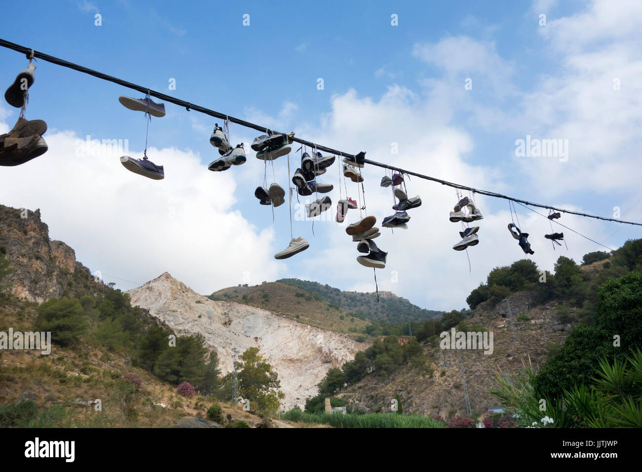 Lots of trainers or running shoes hanging from a cable in Spain Stock Photo