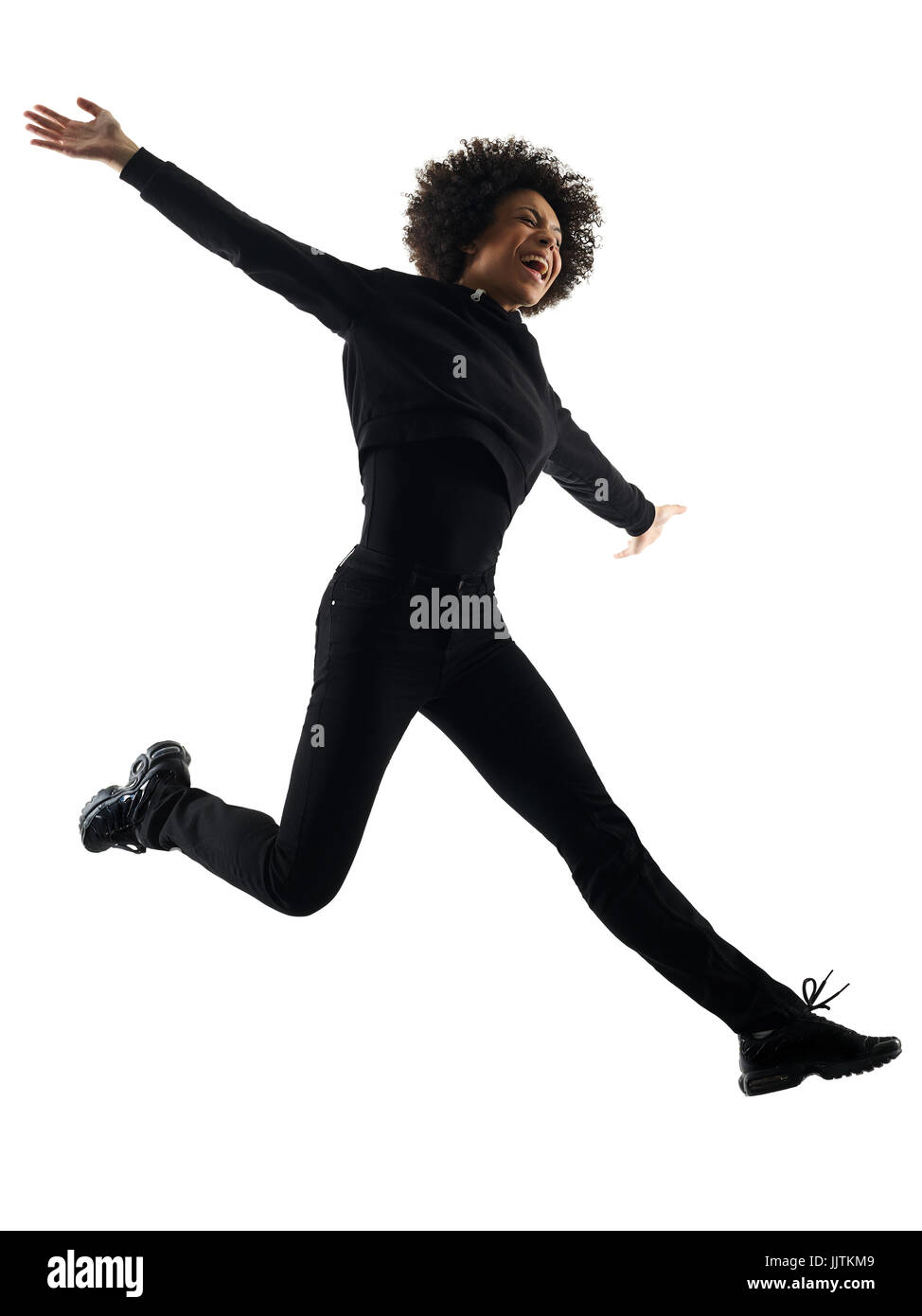 one mixed race african young teenager girl woman jumping happy in studio shadow silhouette isolated on white background Stock Photo