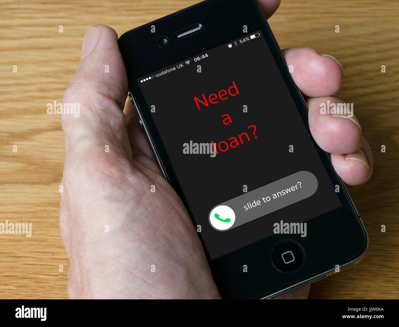 Concept image - Incoming cold call from loan provider on handheld iPhone mobile phone display Stock Photo