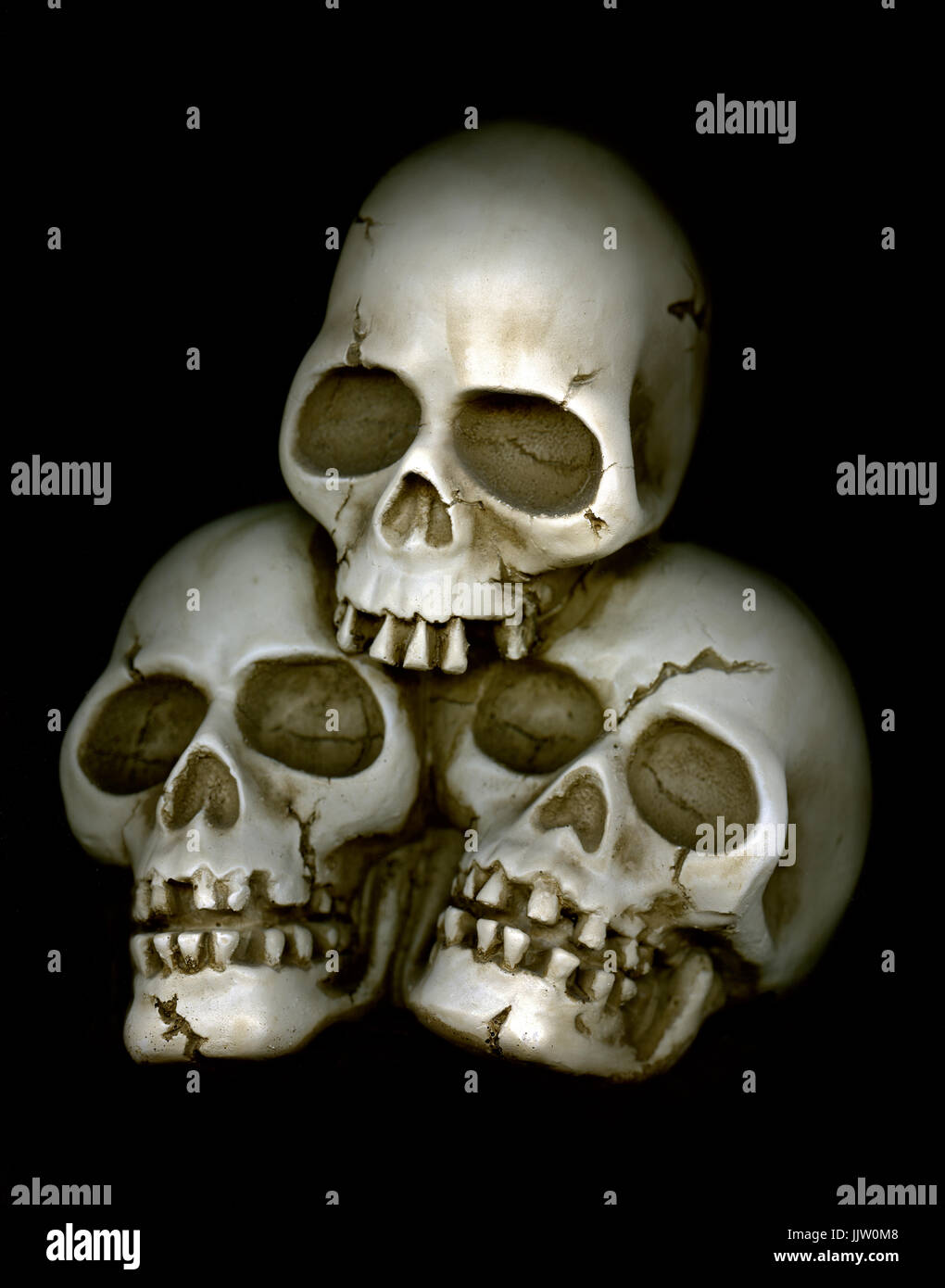 SKULLS  GROUP DEATH DEAD concept 3 skulls close together in a ghoulish deathly group embrace Stock Photo