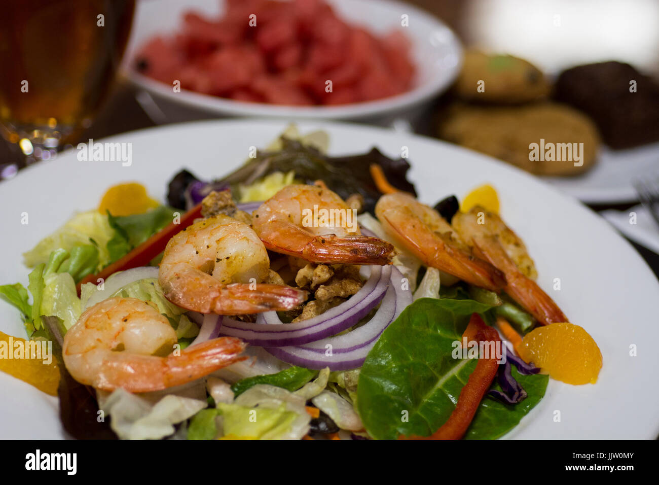 Lunch, Mandarin orange shrimp salad with candied walnuts, watermelon and cookies. Stock Photo