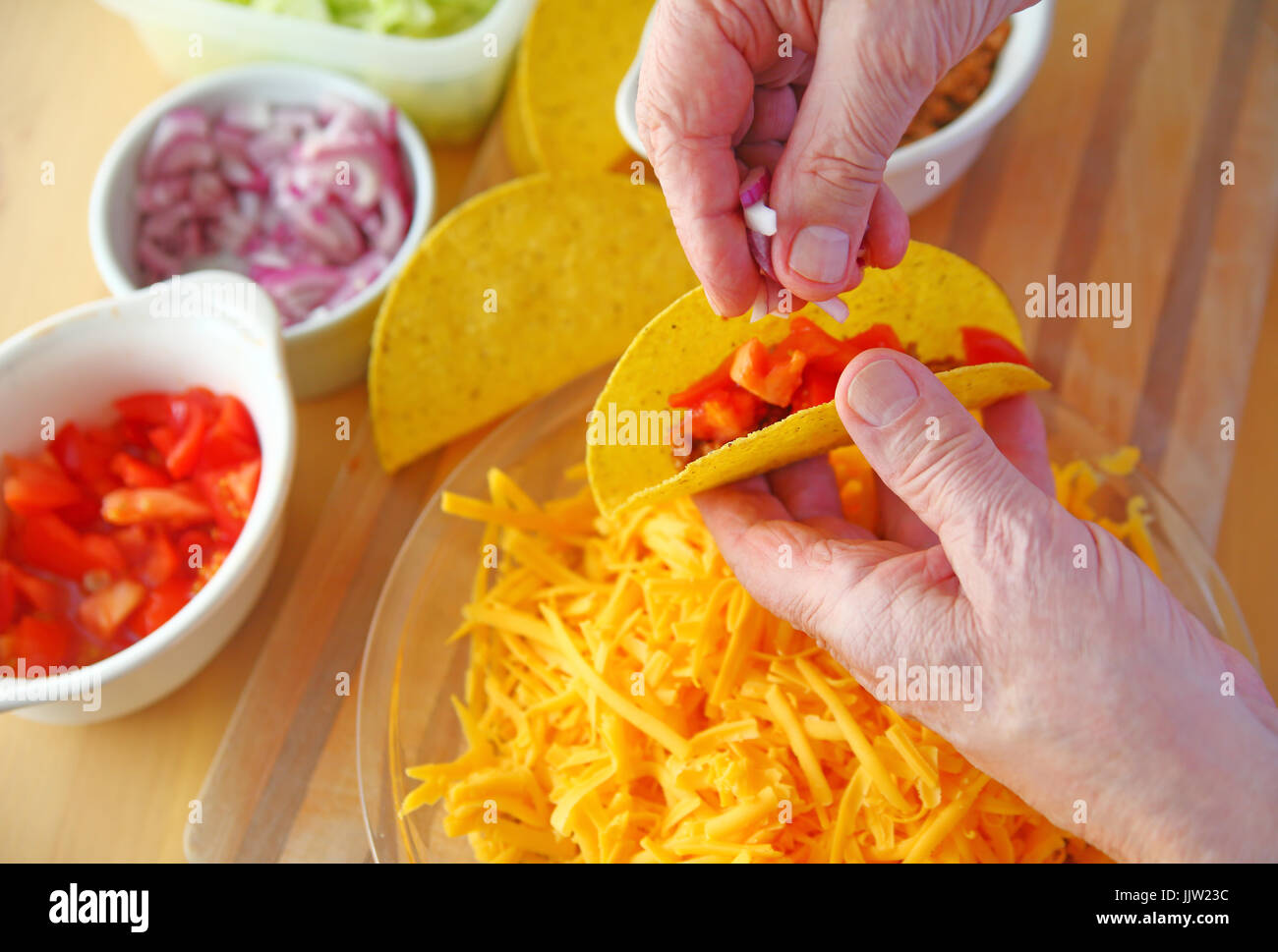 A man adds chopped red onion to his taco Stock Photo Alamy