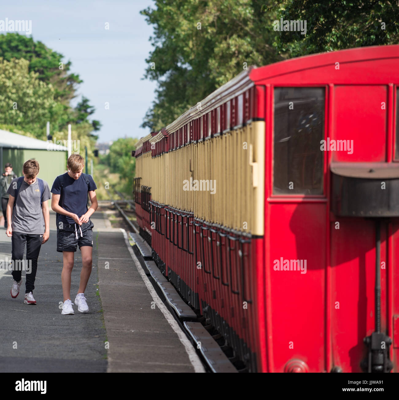 Teenagers walking on steam railway platform Stock Photo