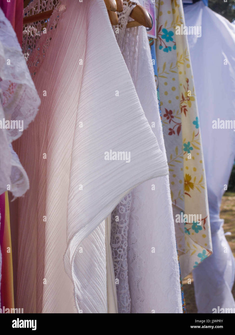 Vintage Women's dresses hanging on a Clothes Rack at a Market Stall Stock Photo