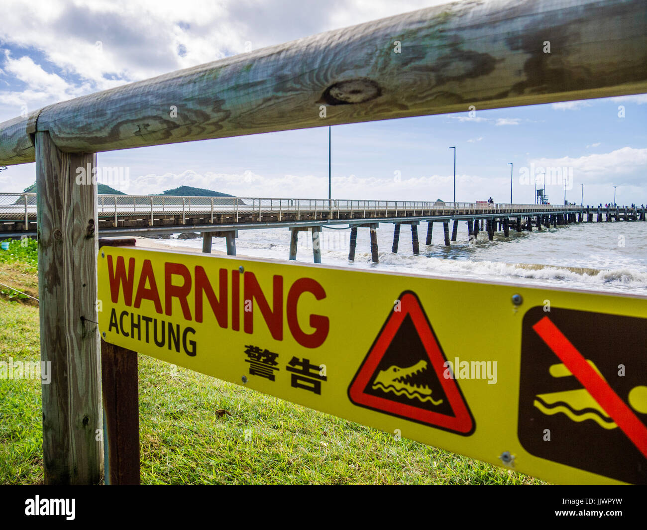 Yellow Danger Sign Warning of Crocodiles on Seashore in Far North Queensland Stock Photo