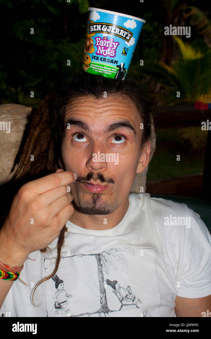 A rastaman having Ben and Jerry's Fairly Nuts ice cream - delicious! Stock Photo