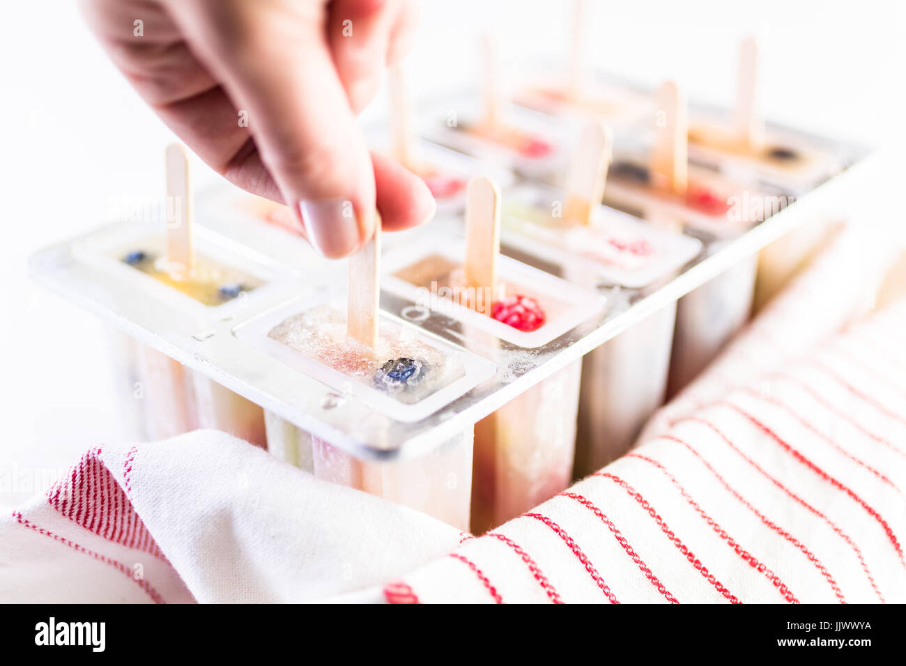 Making homemade fresh fruit popsicles with apple juice in frozn ice pop