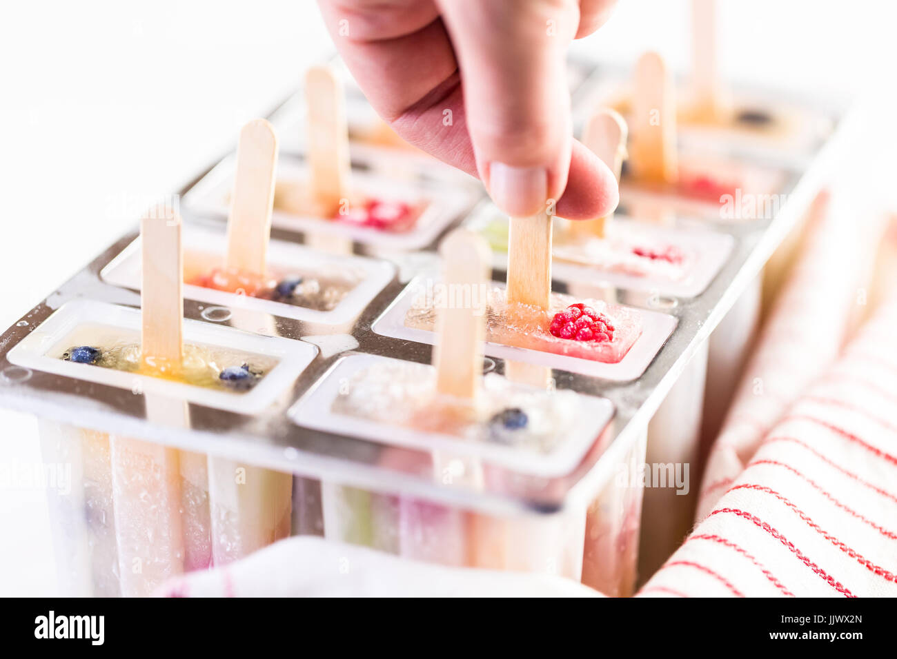 Making homemade fresh fruit popsicles with apple juice in frozn ice pop