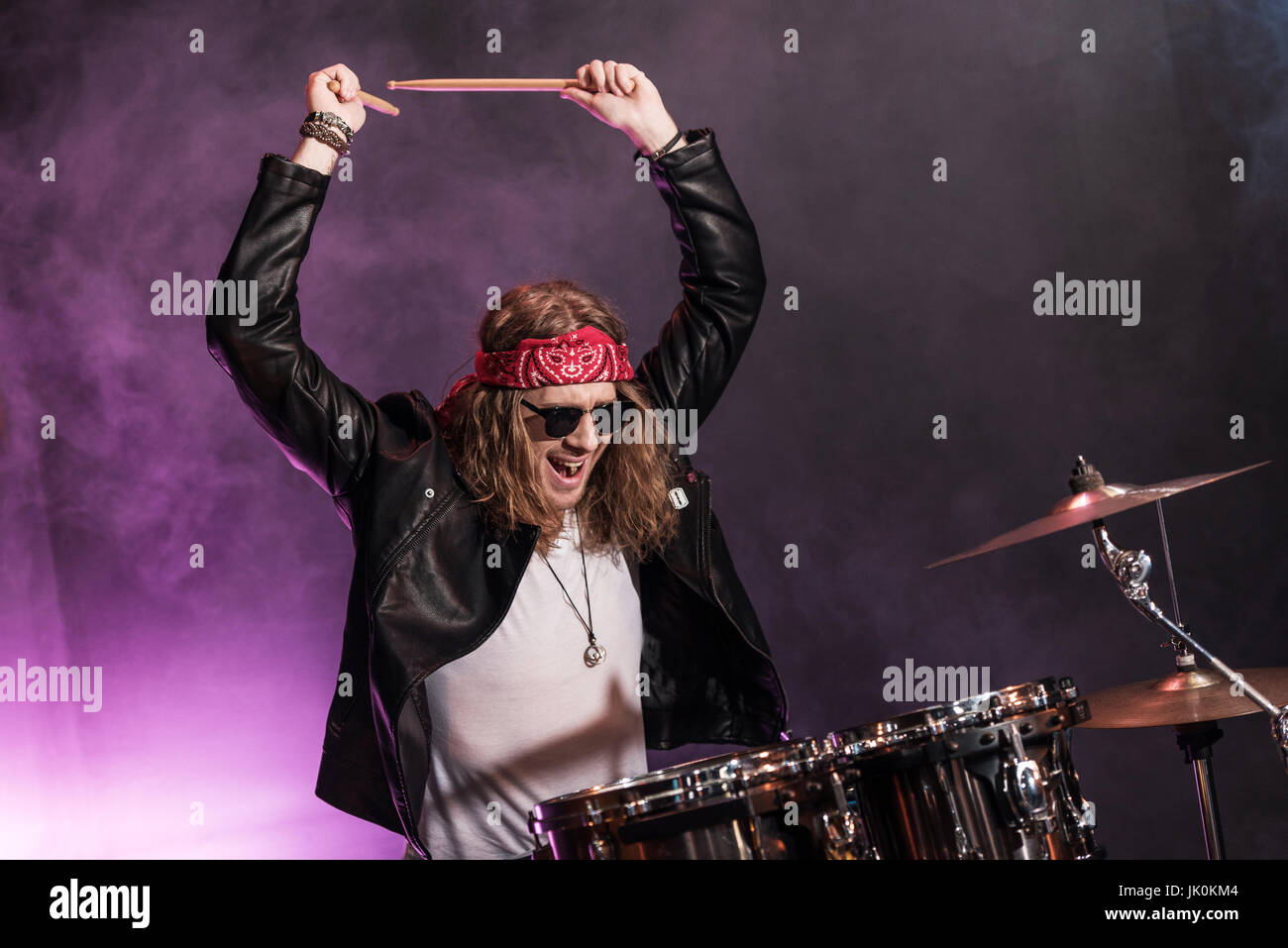 Handsome young man playing hard rock music with drums set Stock Photo