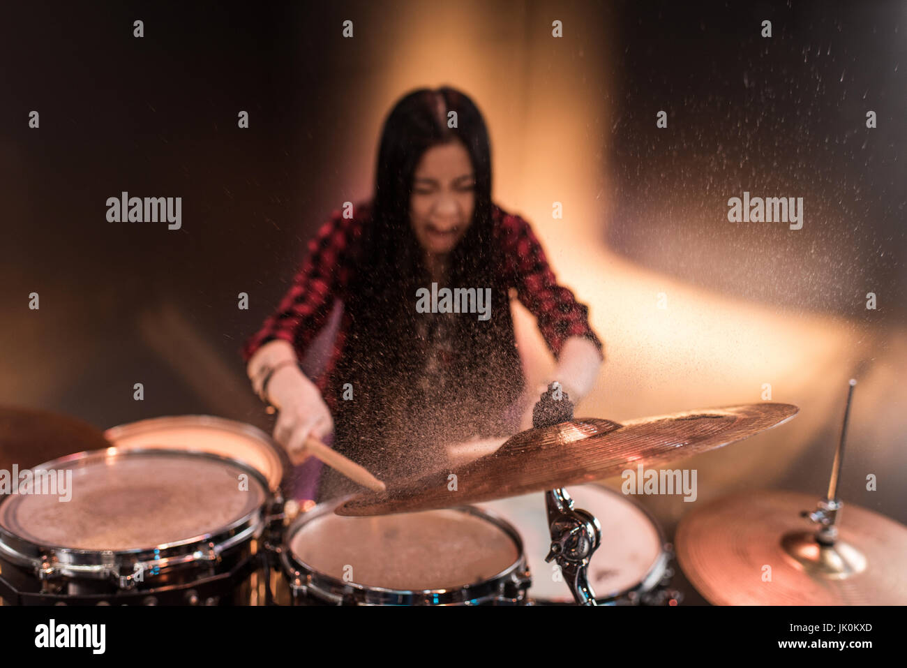 Rock and roll girl playing hard rock music with drums set Stock Photo