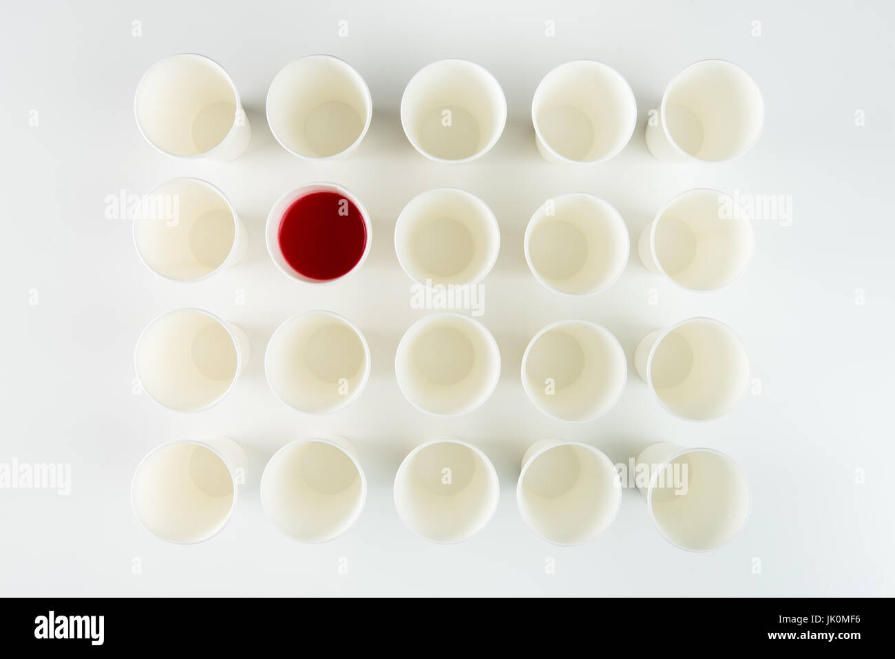 Top view of set of empty plastic cups and one with red paint Stock Photo