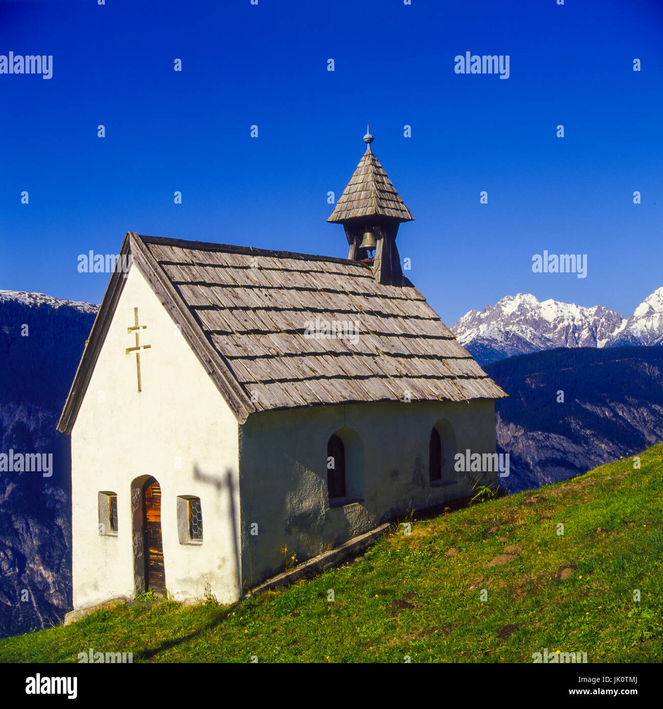 'high about inntal with haiming there sits enthroned the picturesque shingle-covered chapel from hausegg. high up and above the inn-valley, the pictur Stock Photo