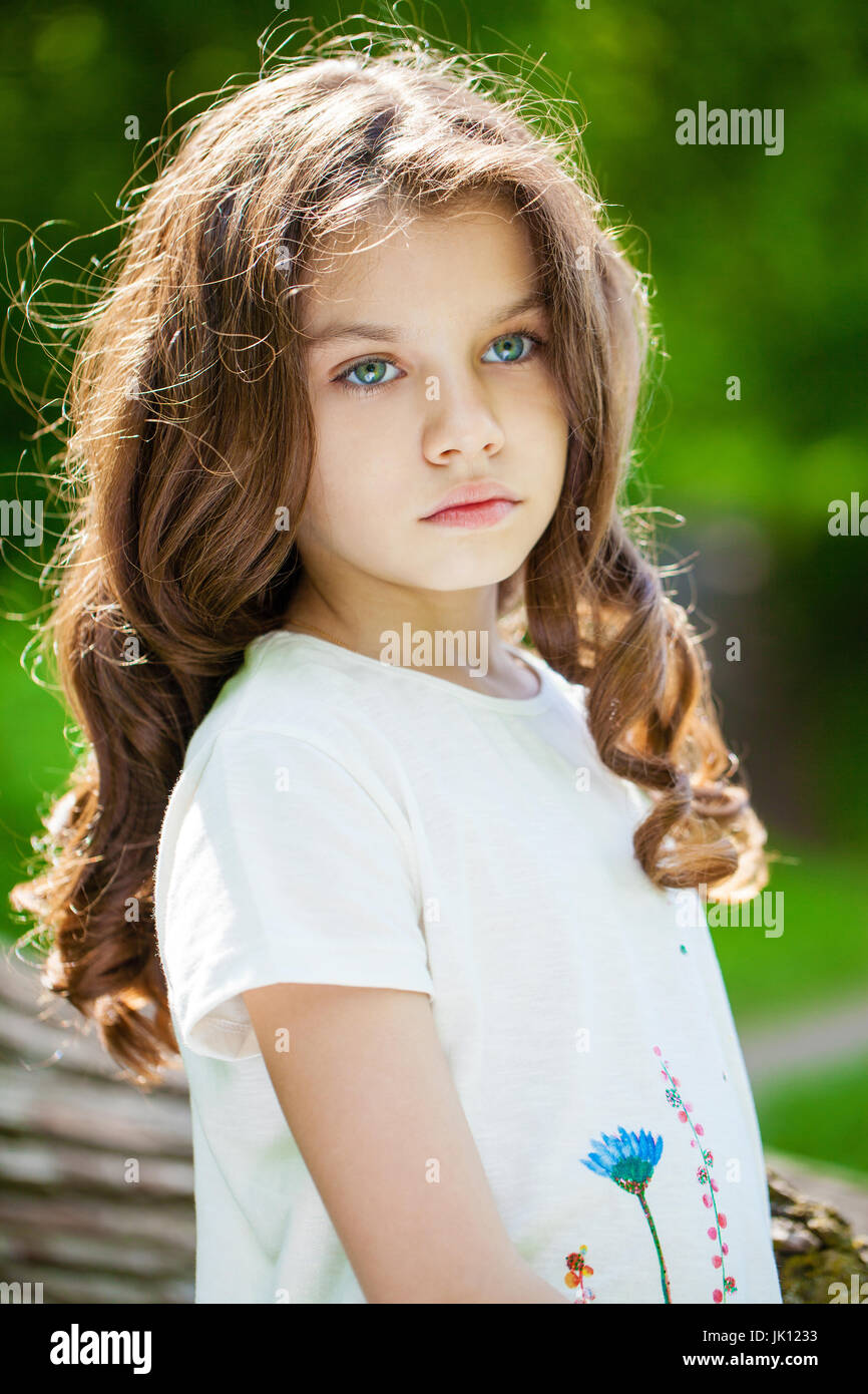 Portrait of a beautiful young little girl on the background of summer ...