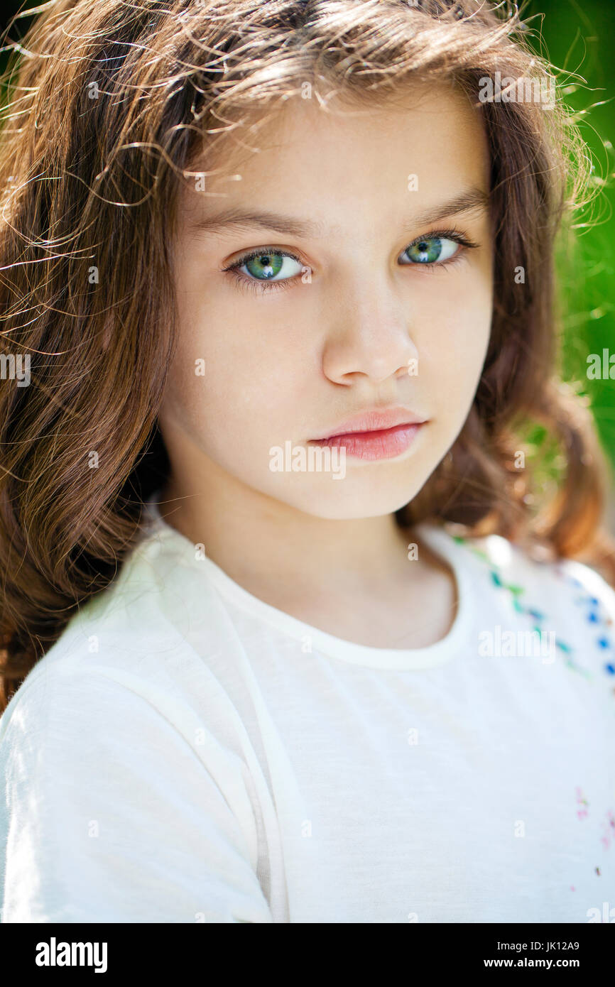 Portrait of a beautiful young little girl on the background of summer ...