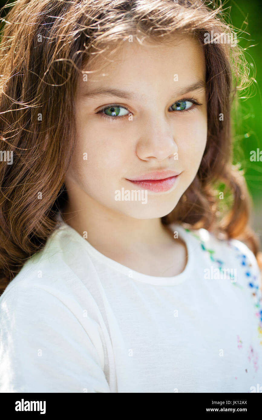 Portrait of a beautiful young little girl on the background of summer ...
