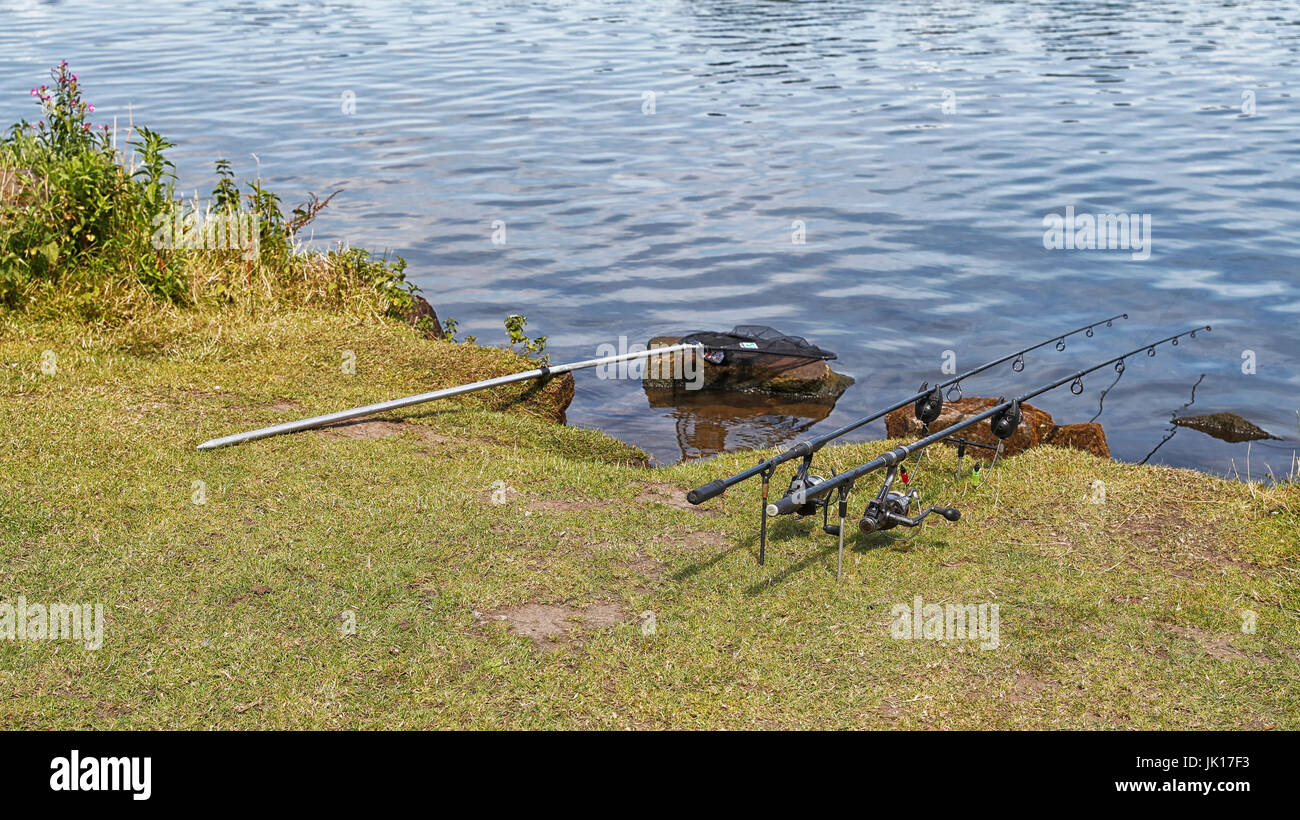 Fishing rods at the ready on a river bank. Stock Photo