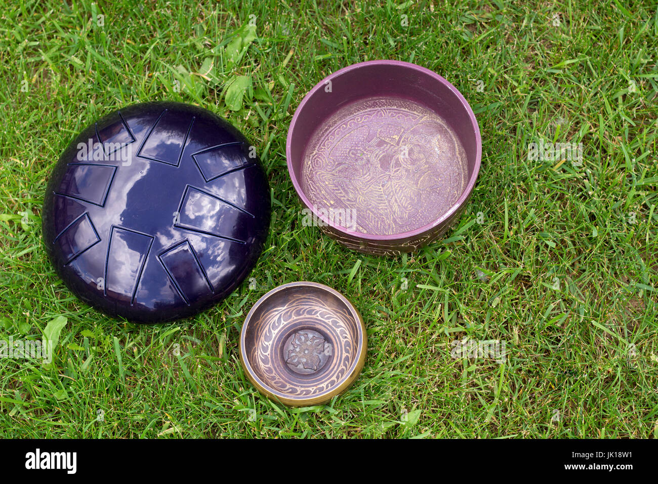 singing bowls and steel tongue drum on the grass top view Stock Photo