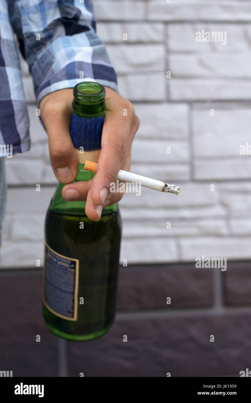 hand of young man with beer bottle and a cigarette Stock Photo - Alamy
