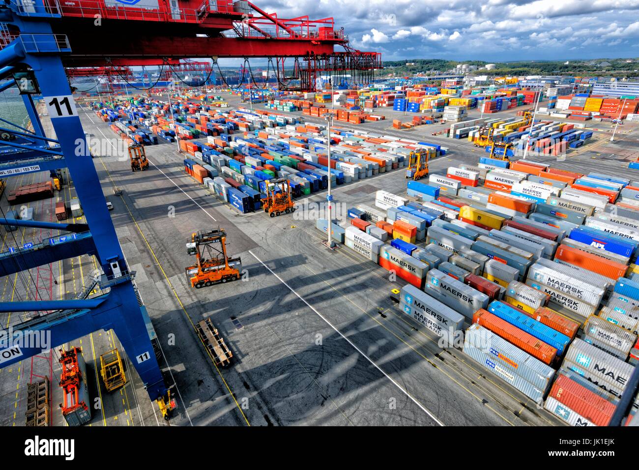 Container port with cranes and trucks in action. Aerial perspective from high above. Stock Photo