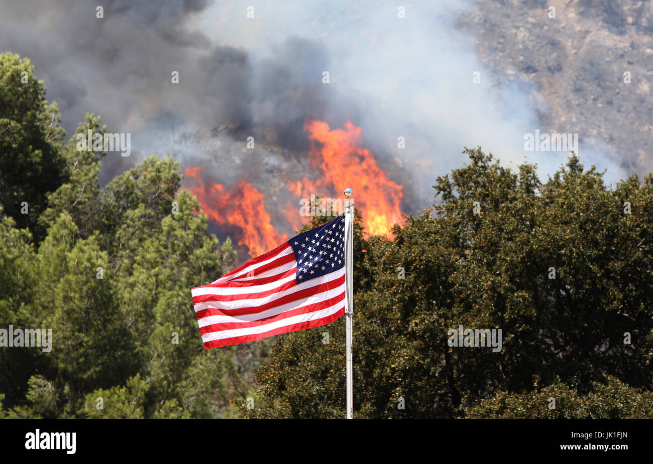 A US Flag with the Blue Cut Fire burning behind in Lytle Creek, California, USA on 17th of August 2016. Stock Photo