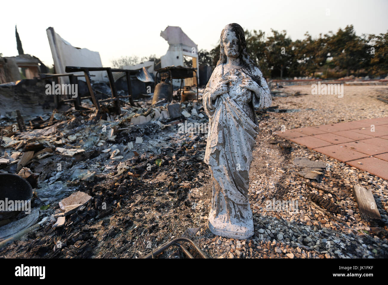 A statue of the Virgin Mary by a burned farm house which has been distroyed by the Blue Cut Fire in Phelan, California, USA on 17th of August 2016. Stock Photo
