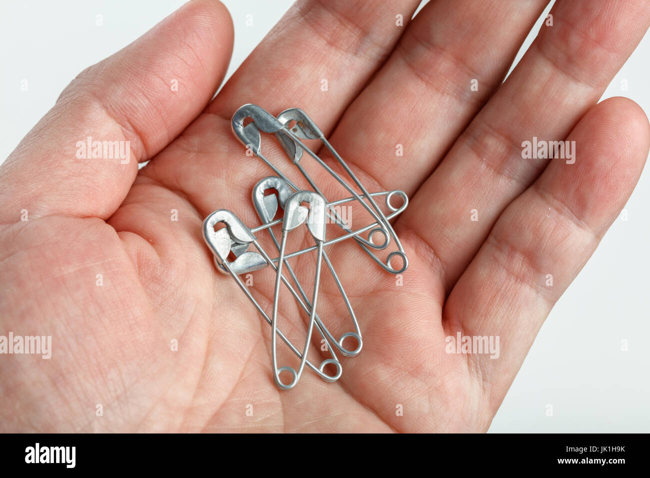 Hand holding sewing safety pins, close up Stock Photo Alamy
