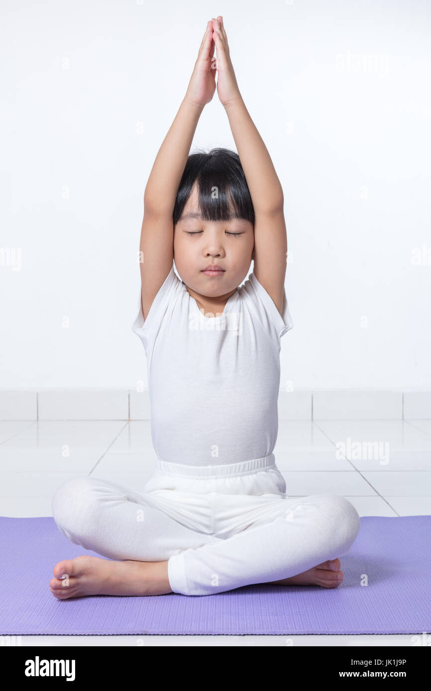 Little girl practicing yoga on white background Stock Photo - Alamy