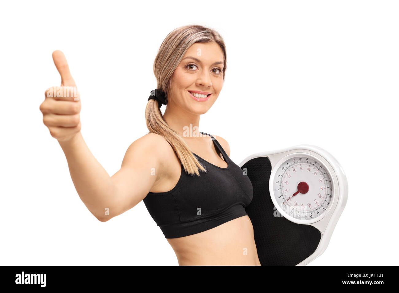 Young woman with a weight scale making a thumb up gesture isolated on white background Stock Photo