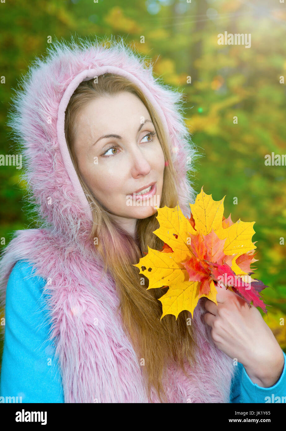 The beautiful woman in autumn park with maple leaves Stock Photo - Alamy